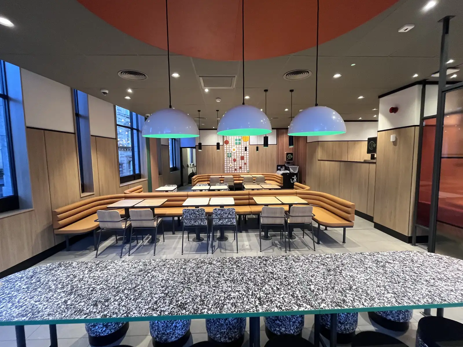 Terrazzo feature table under domed pendant lights in a fast serve restaurant dining room in Halifax