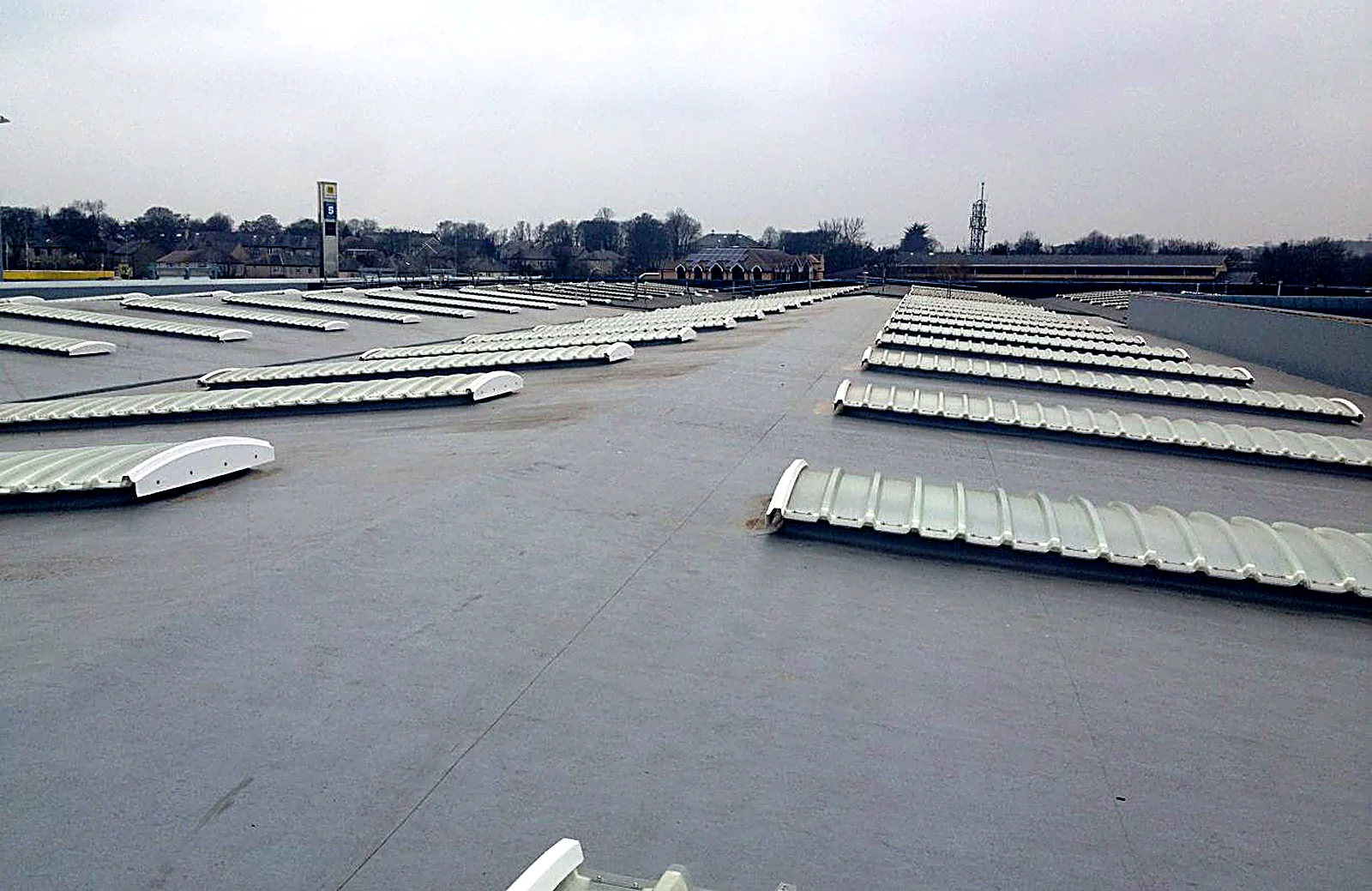 Grey single-ply membrane roof with rows of barrel rooflights