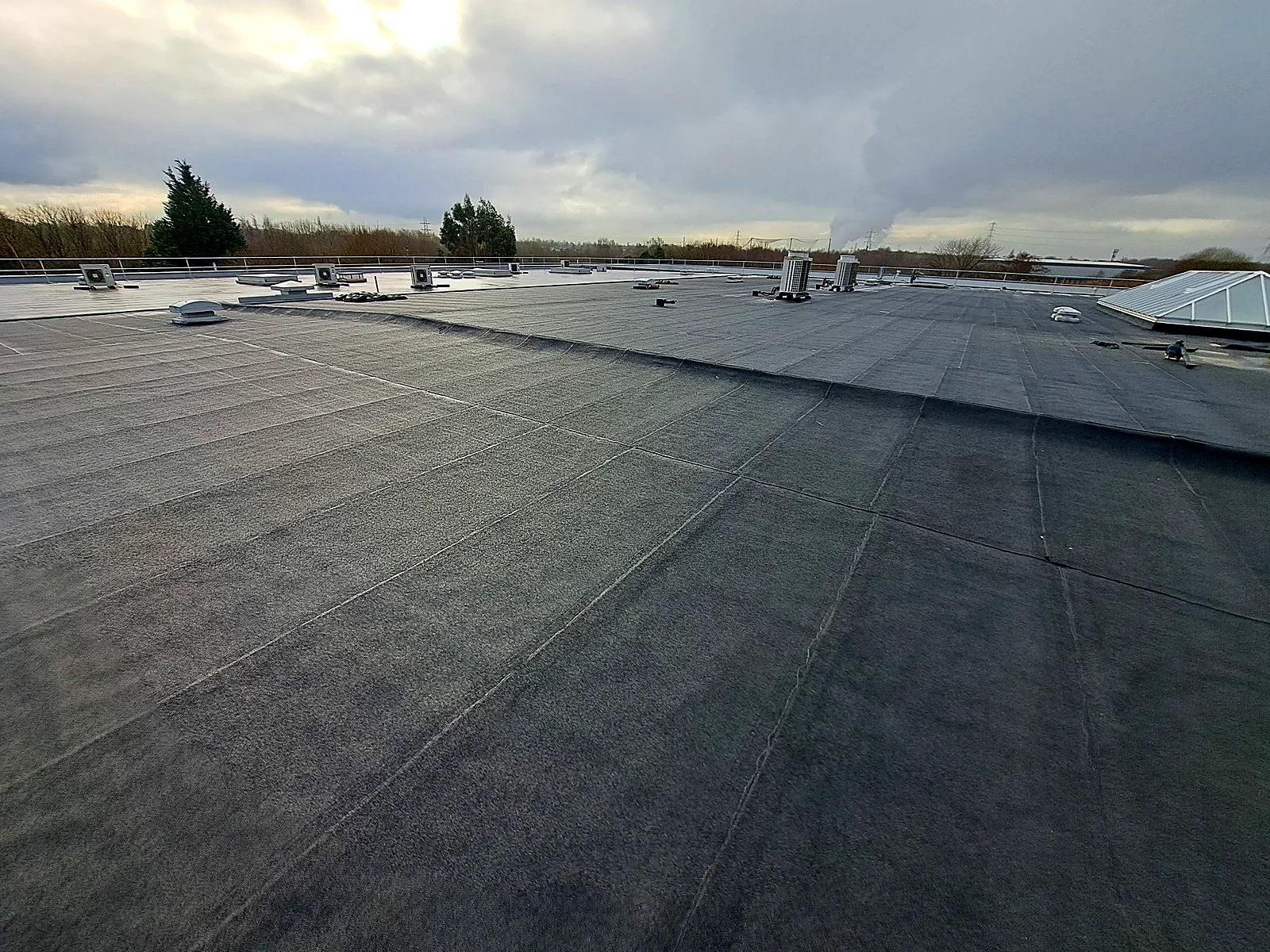 New felt flat roof stretching across a large commercial building