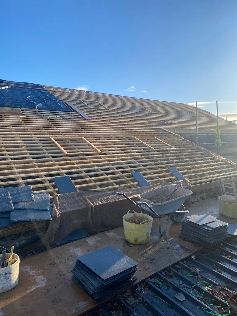 Slates stacked on the roof ready for laying over new battens and membrane