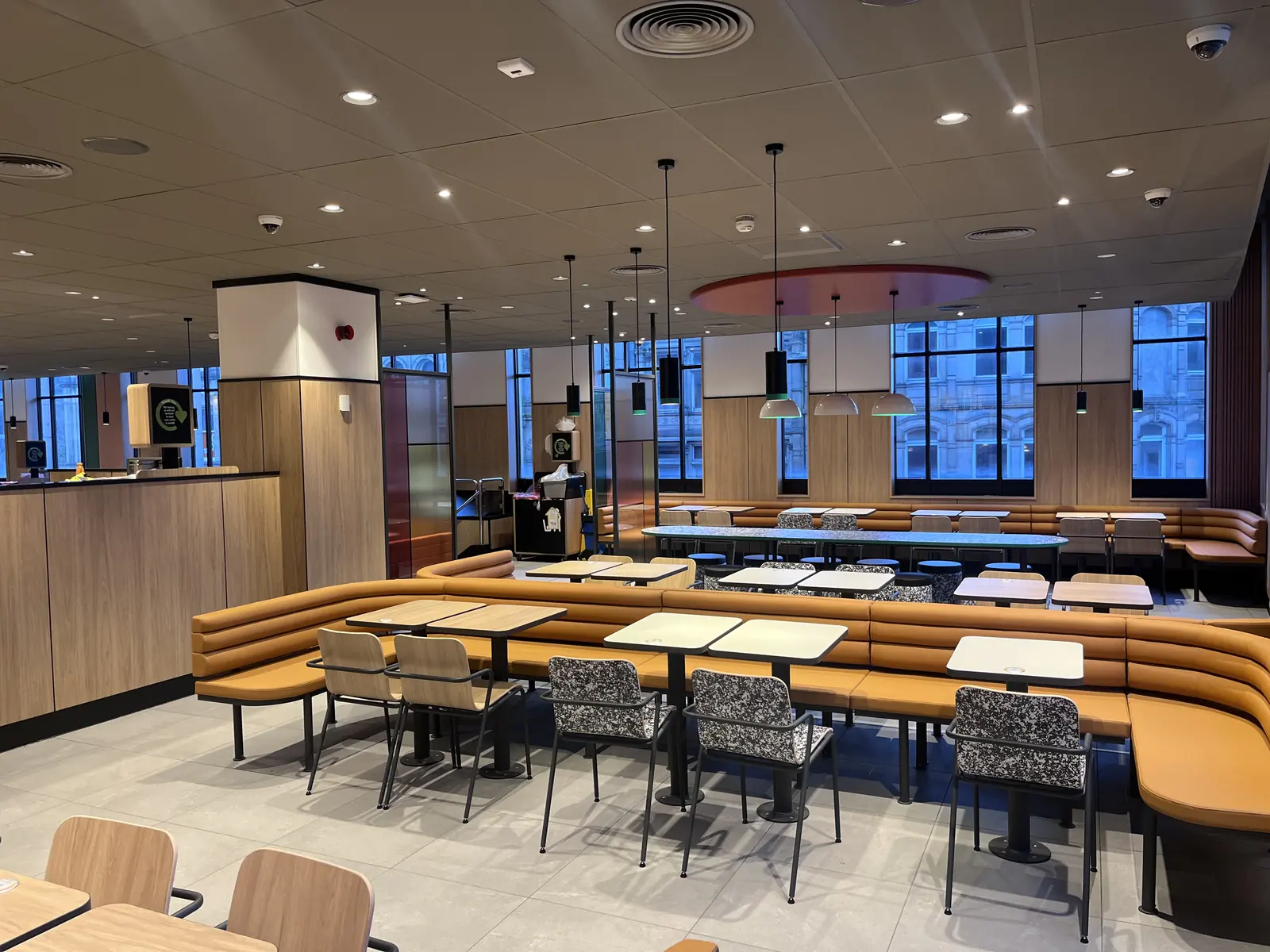 Fast serve restaurant in Halifax, dining area with tan banquette seating, timber panelling and tall windows