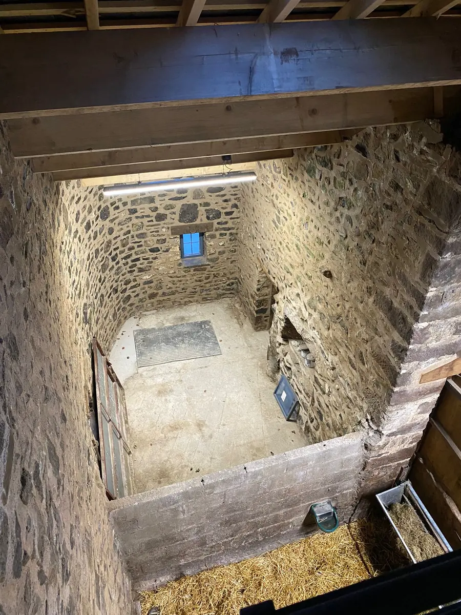 Looking down into a restored barn bay with repointed stone walls
