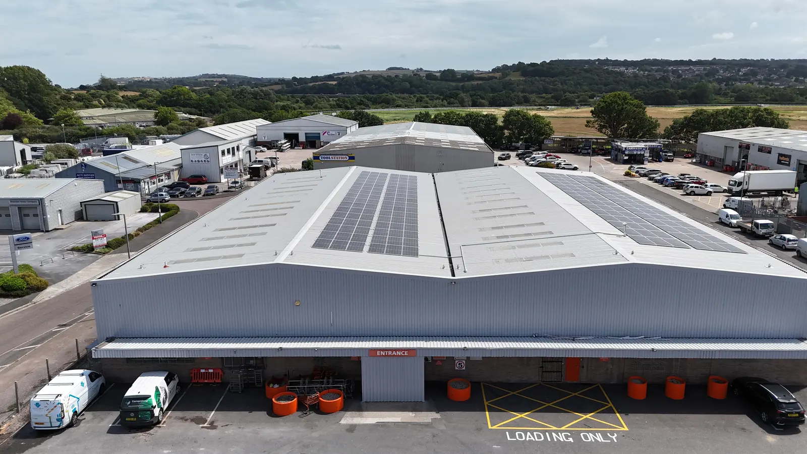 Booker Newton Abbott front elevation from the air with solar on the roof and loading bays below
