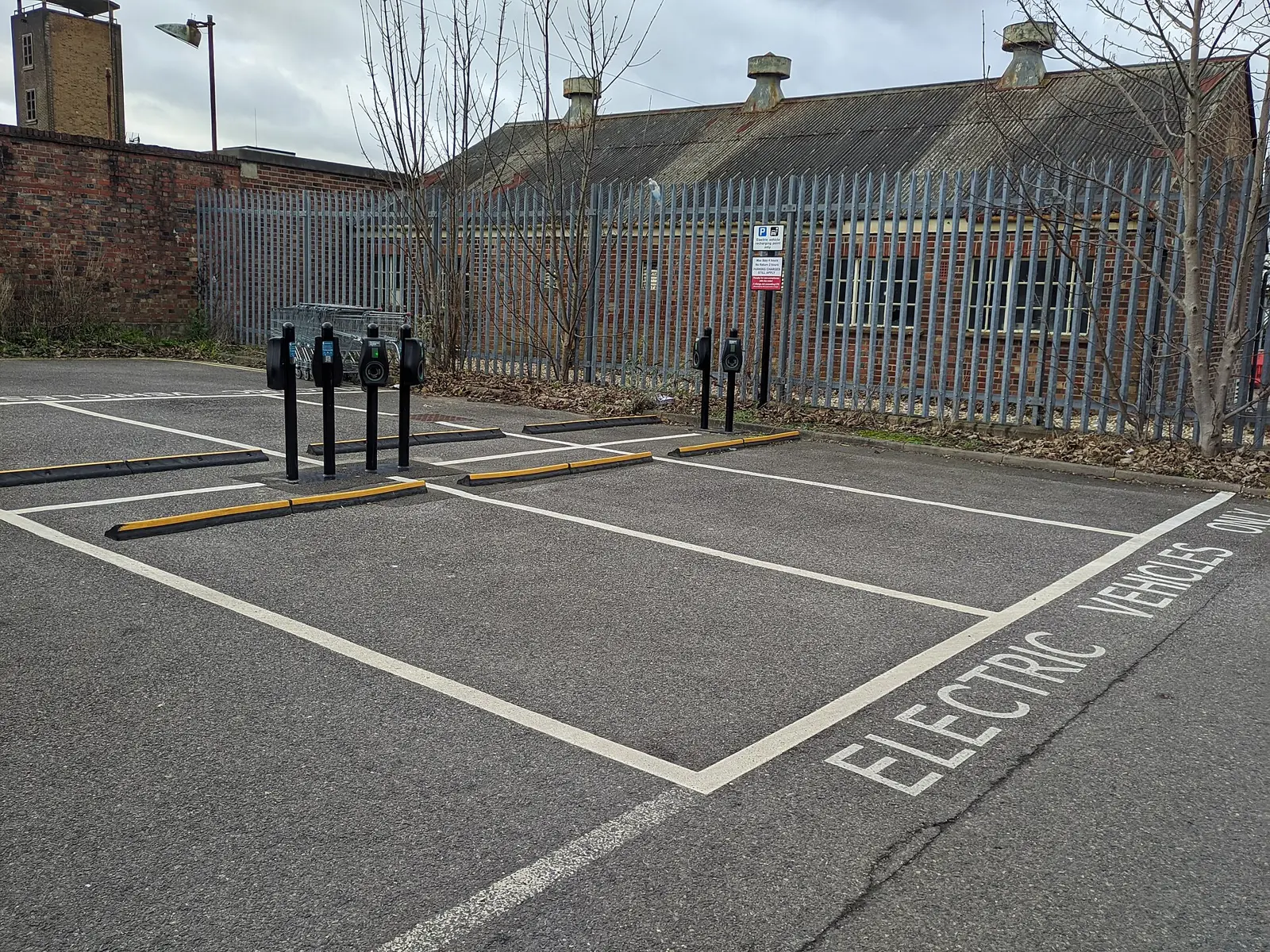 A row of EV charge points beside electric-vehicle-only bays in a workplace car park