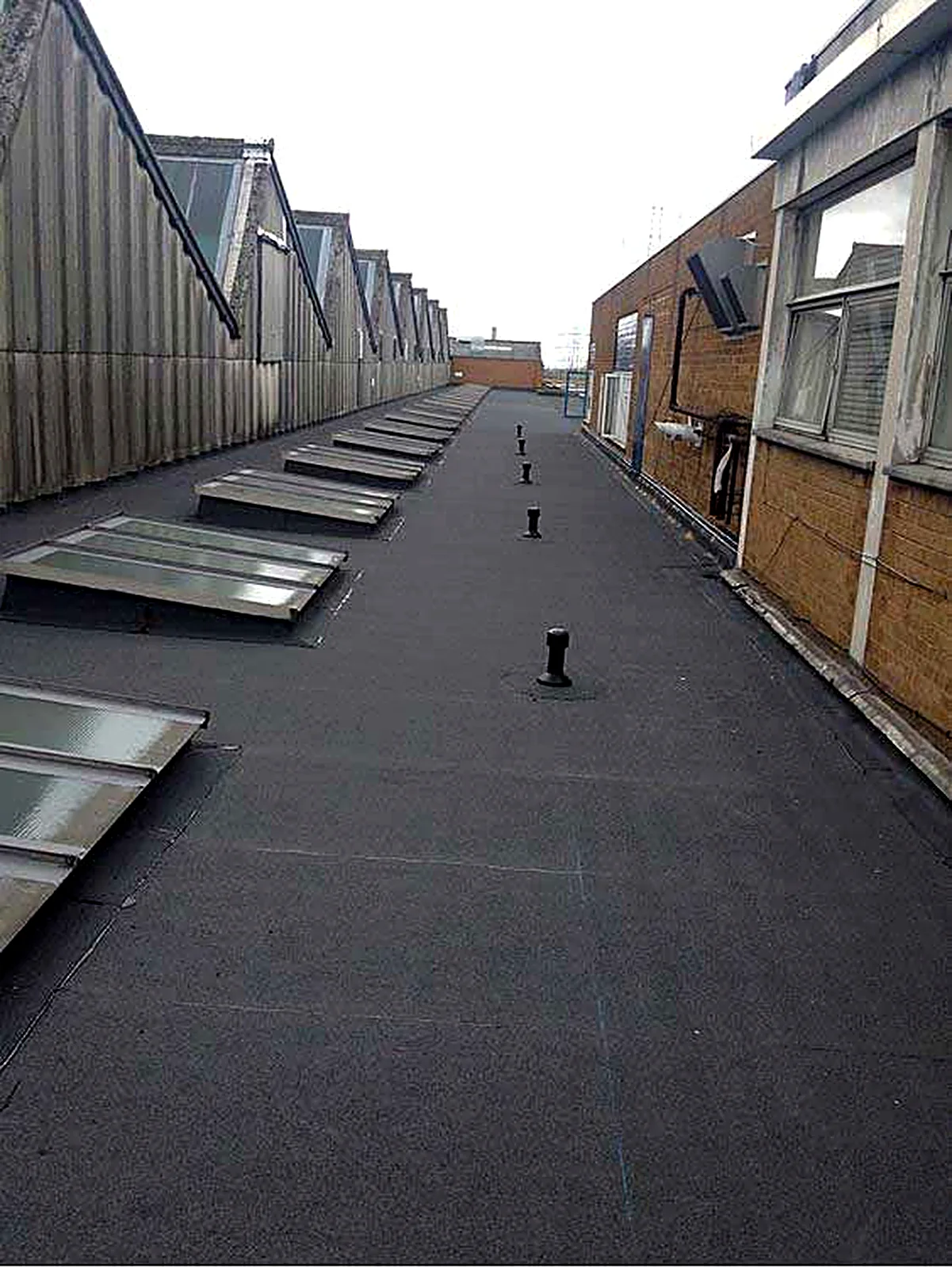 New felt overlay running alongside a sawtooth factory roof