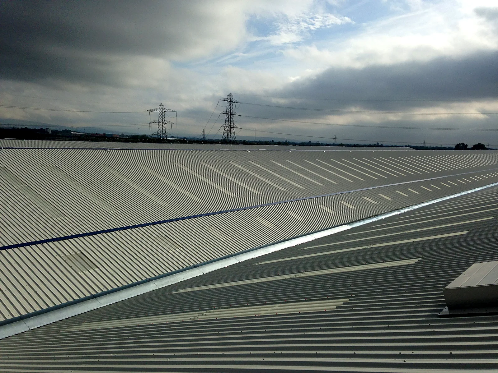 Long run of new profiled metal roof sheets on the Mono Pumps building
